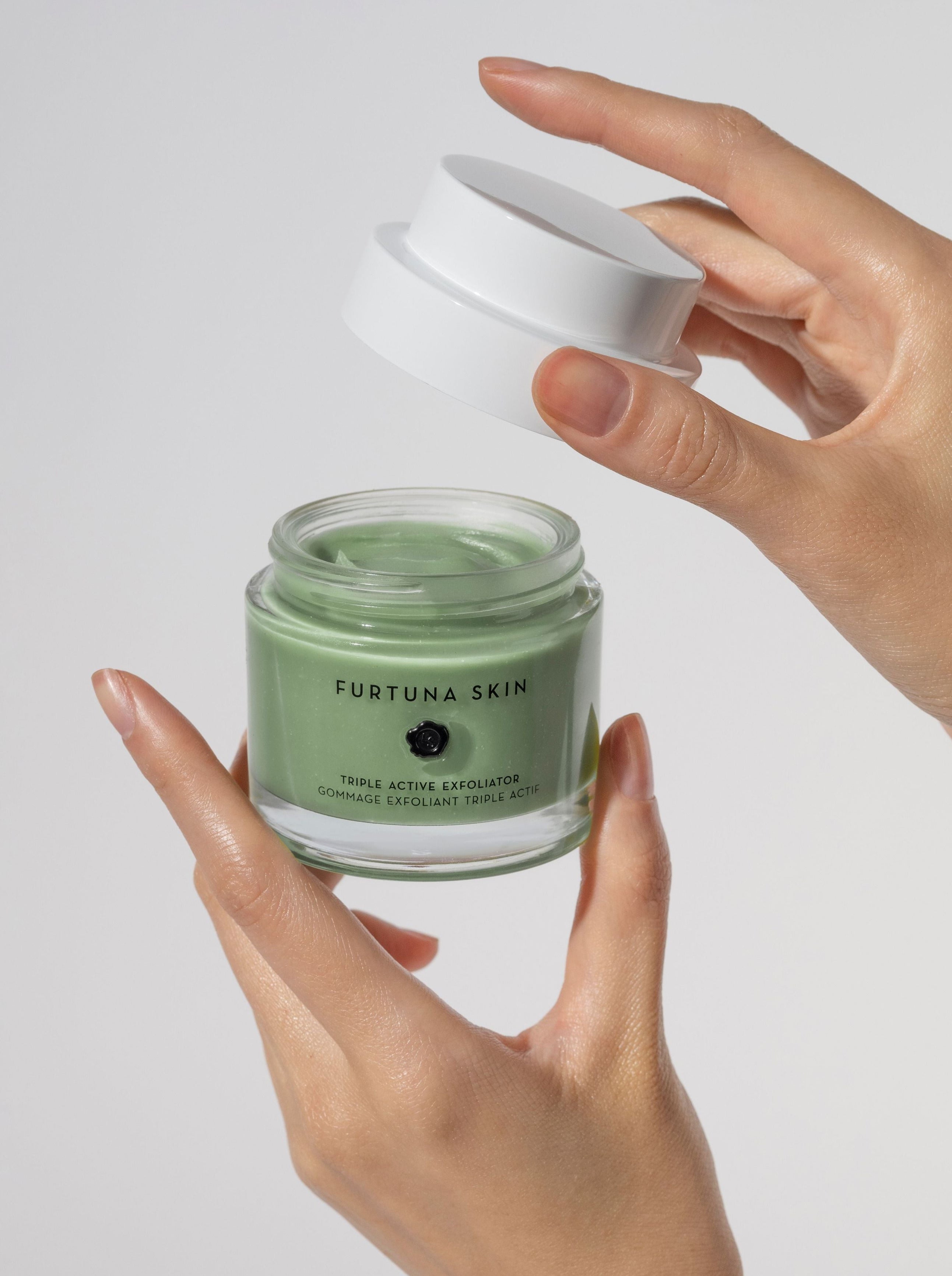 Furtuna Skin Triple Active Exfoliator product held by two hands